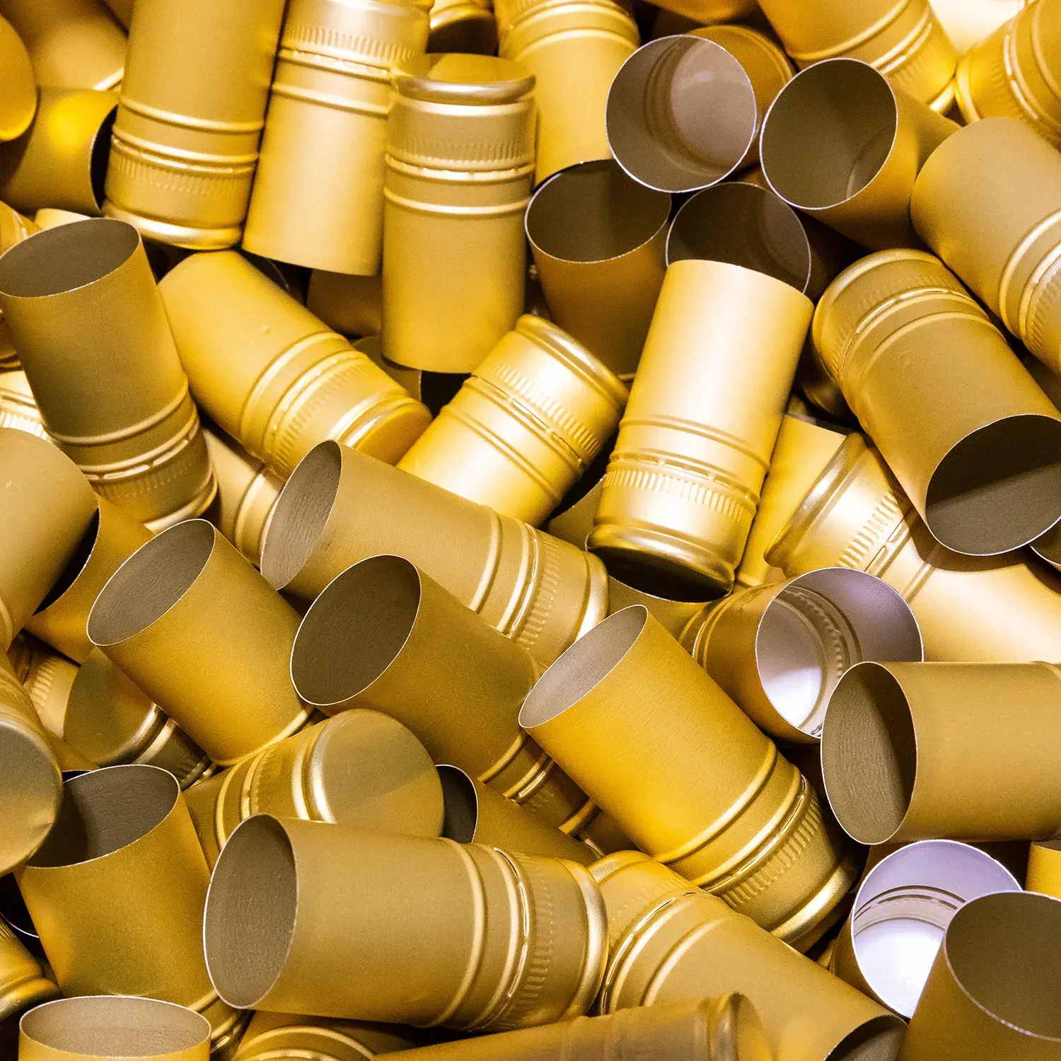 Nahaufnahme goldener Verschlusskapseln auf bimalo Cider-Flaschen als Zeichen für höchste Qualitätsstandards und Exzellenz in jedem Schluck.